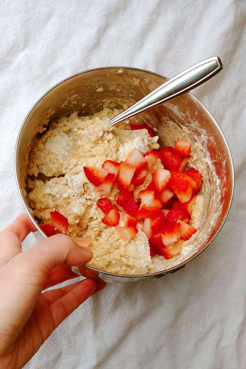 dough for strawberry and cream scones, in a mixing bowl with a spoon