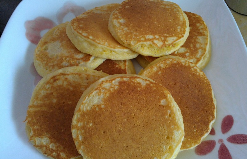 lemon cornmeal pancakes, overlapping on a plate