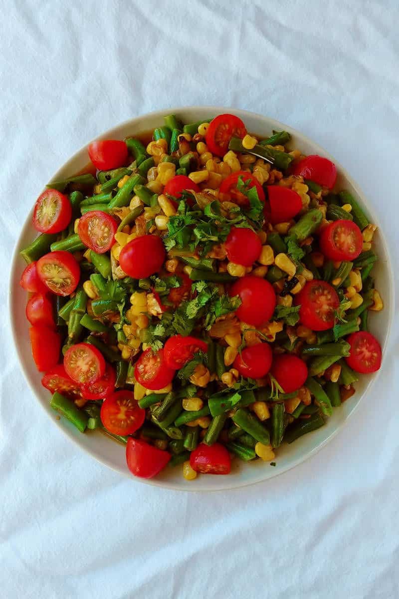 corn and green bean salad with tomatoes and lime dressing, on a plate