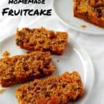 alton brown's fruitcake, slices on plates, with a bottle in the background - pin for pinterest
