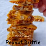 a stack of microwave peanut brittle, with a hand placing another piece on top - pin for Pinterest