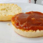 an english muffin, split and toasted, with apple butter on one half