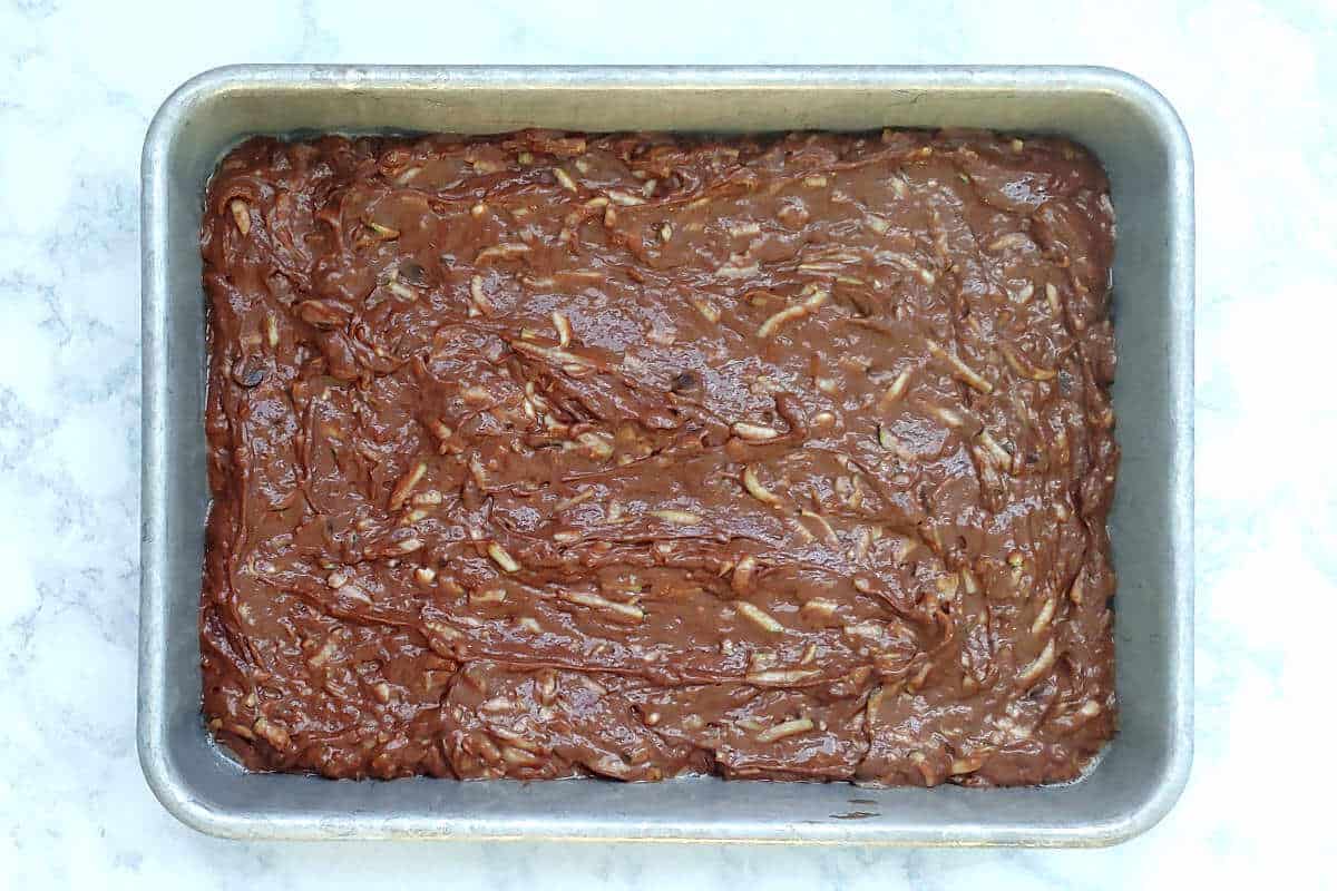 batter for chocolate zucchini cake, in a metal pan