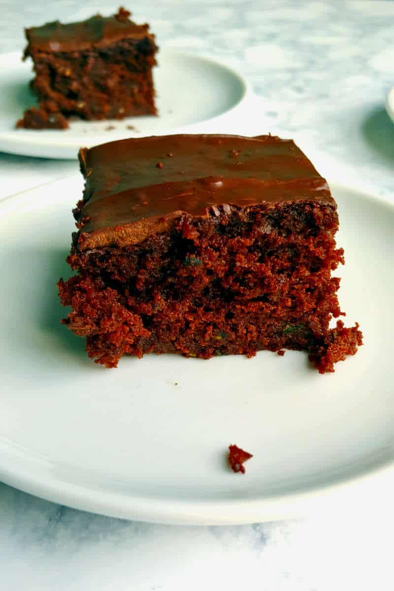 chocolate zucchini cake, on a plate, with another slice in the background