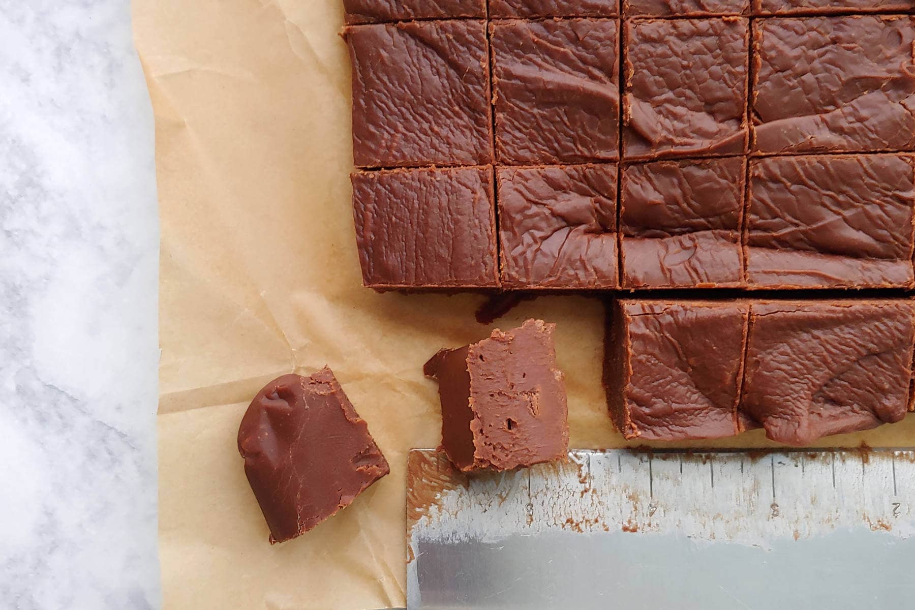 squares of cut fudge, with one on its side to show texture