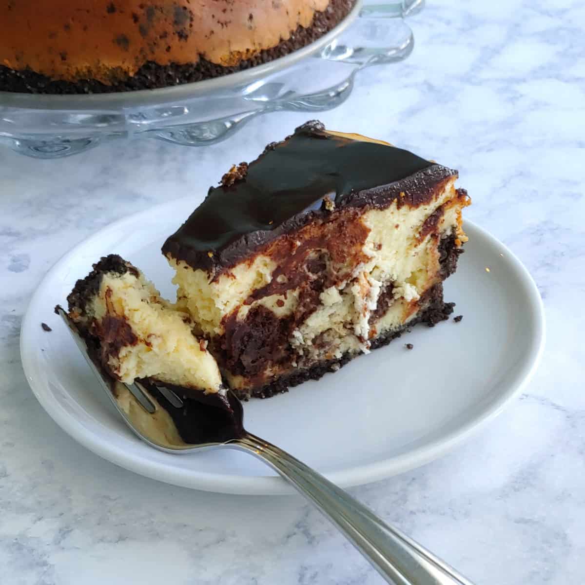 slice of brownie cheesecake, with a bite on a fork